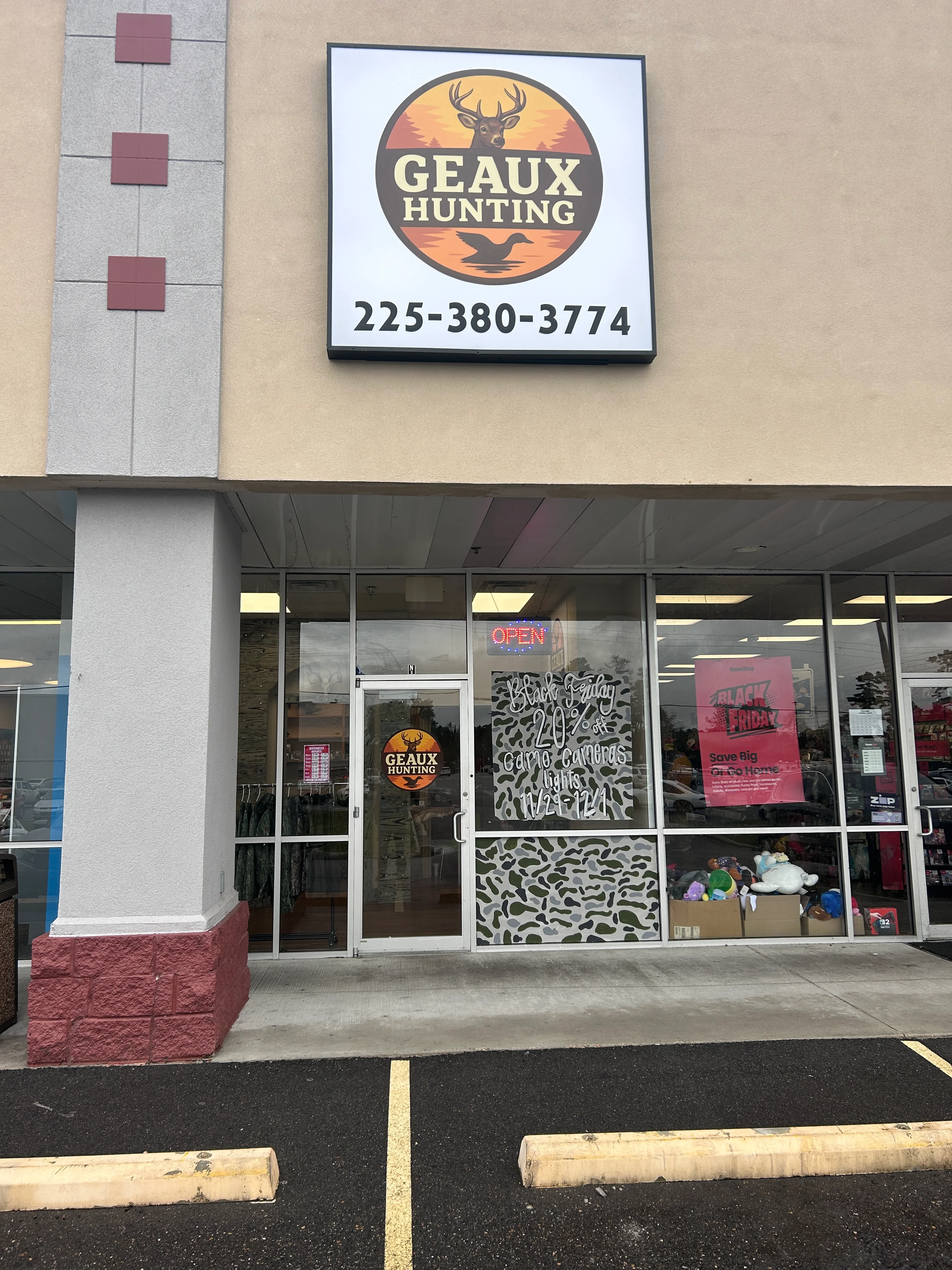 Exterior of Geaux Hunting store with open sign and promotional window display