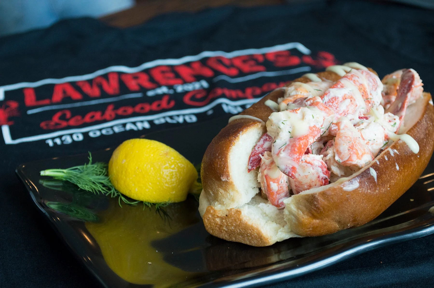 Lobster roll served on a soft bun with lemon garnish