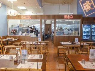 Cozy indoor dining area with wooden tables and warm lighting.