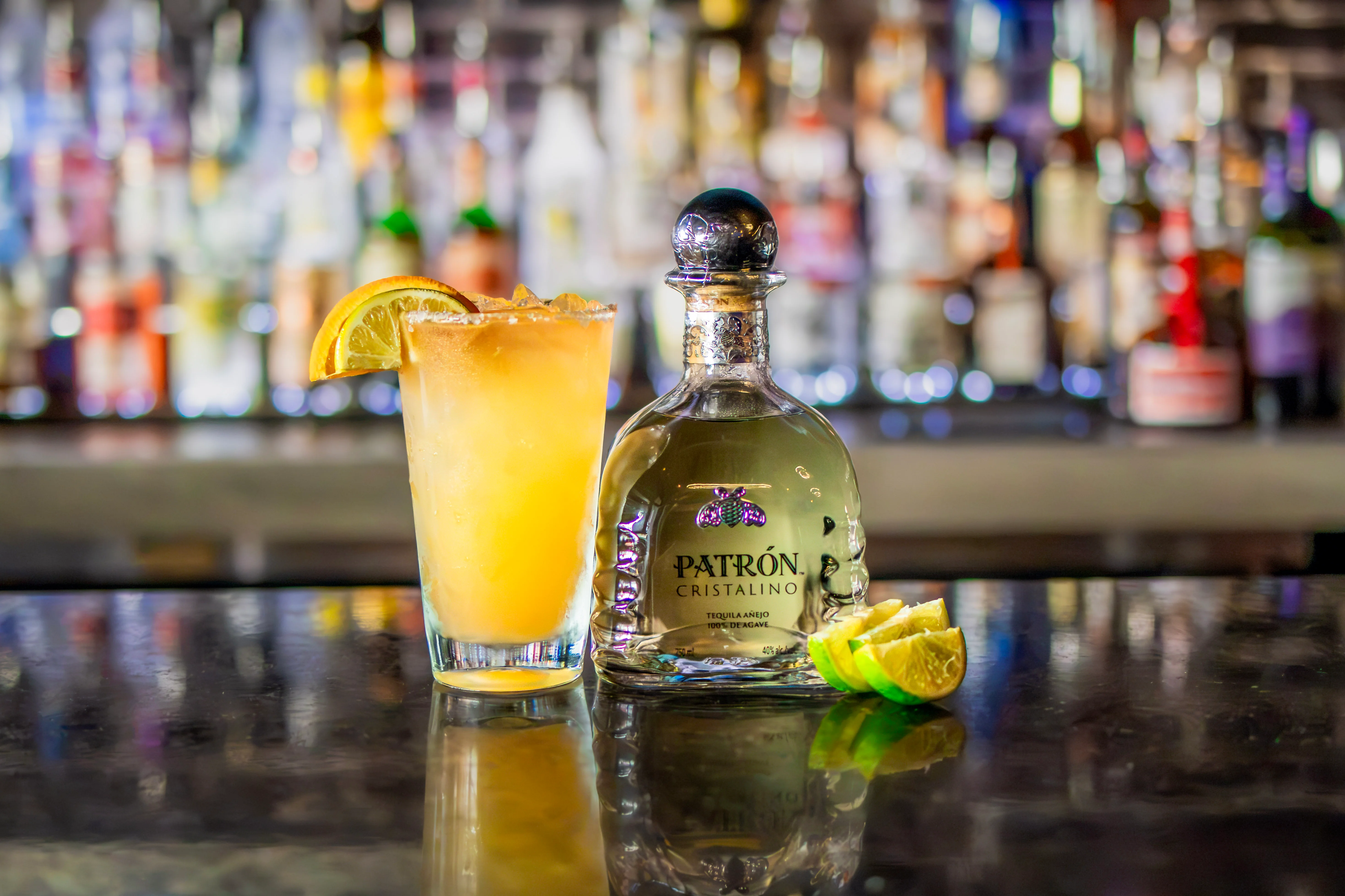 Refreshing cocktail with Patrón tequila and citrus garnish on a bar counter