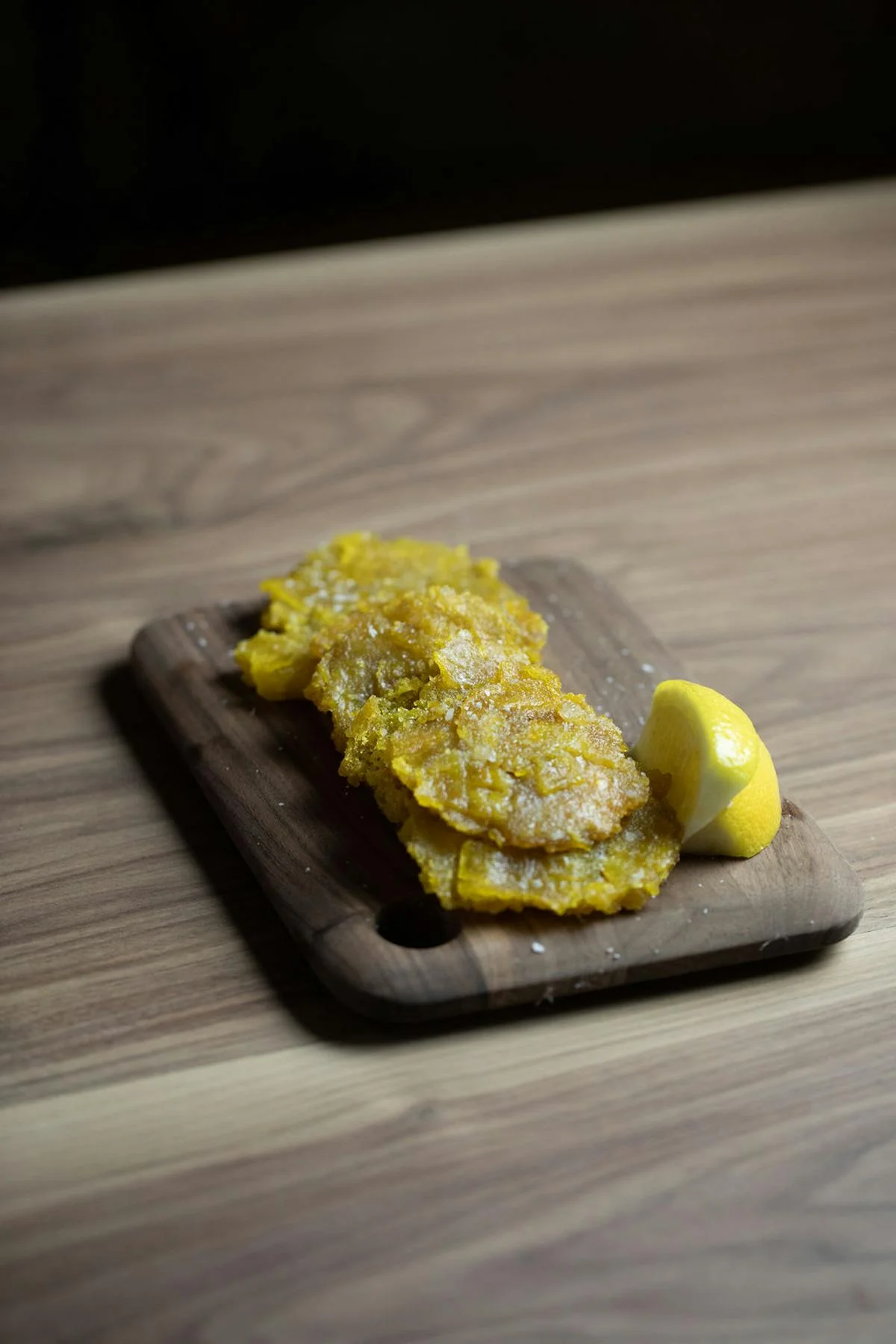 Crispy Latin American tostones served with a lemon wedge