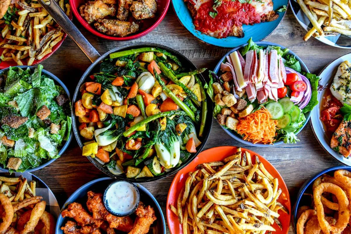 Assorted American comfort food platters with salads and fried dishes