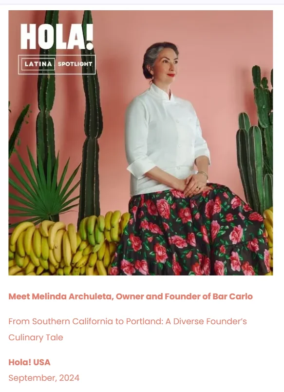 Melinda Archuleta, chef in white coat, with floral skirt and tropical backdrop.