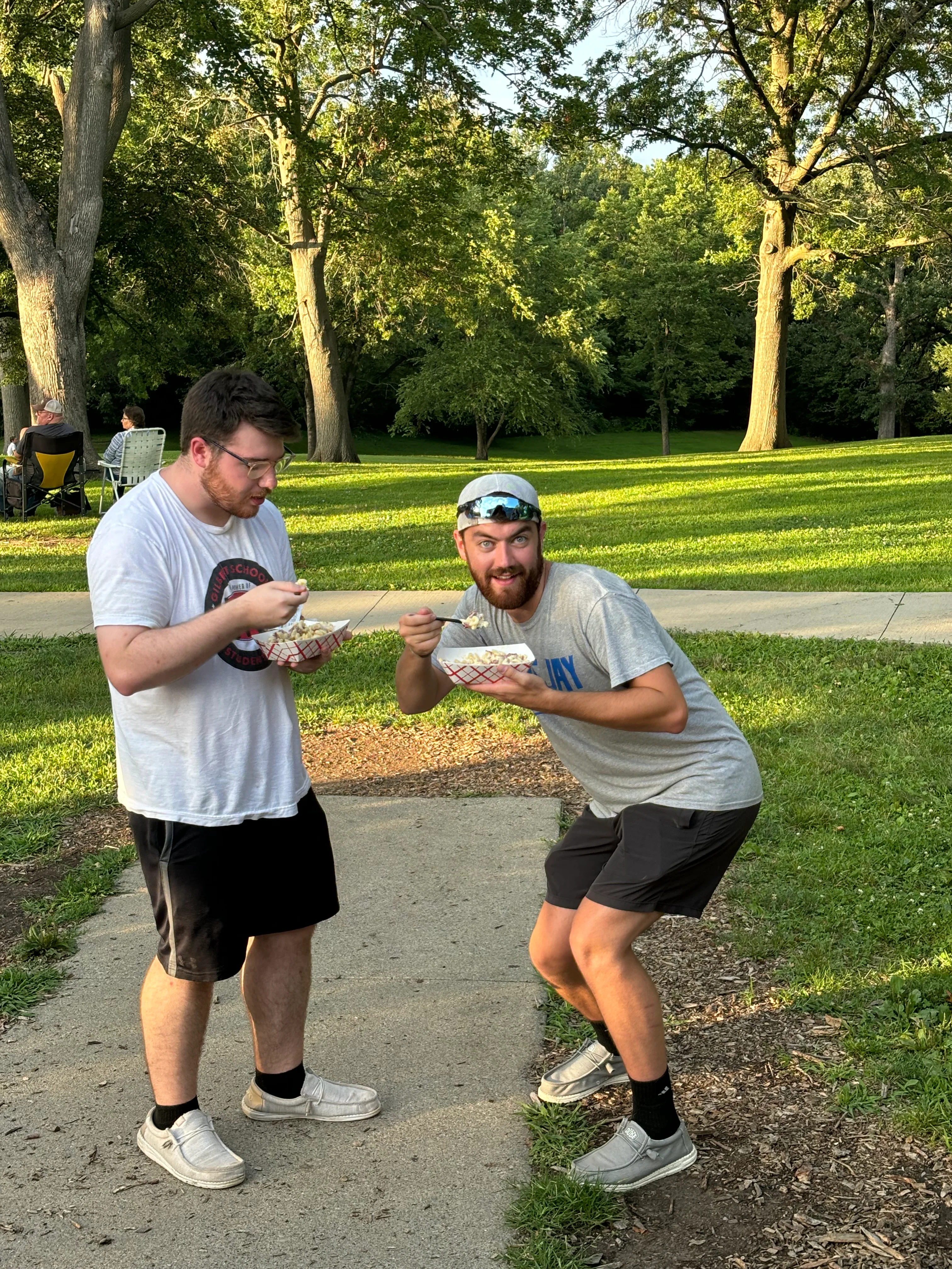 Two friends enjoying ice cream cones in a park