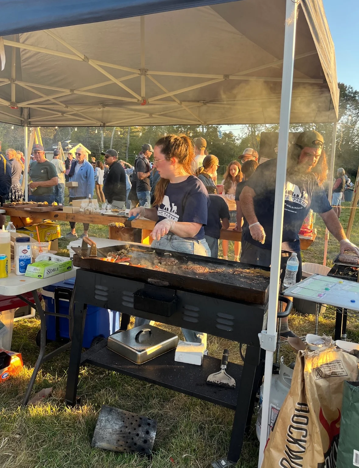 Grilling burgers at a lively outdoor food festival