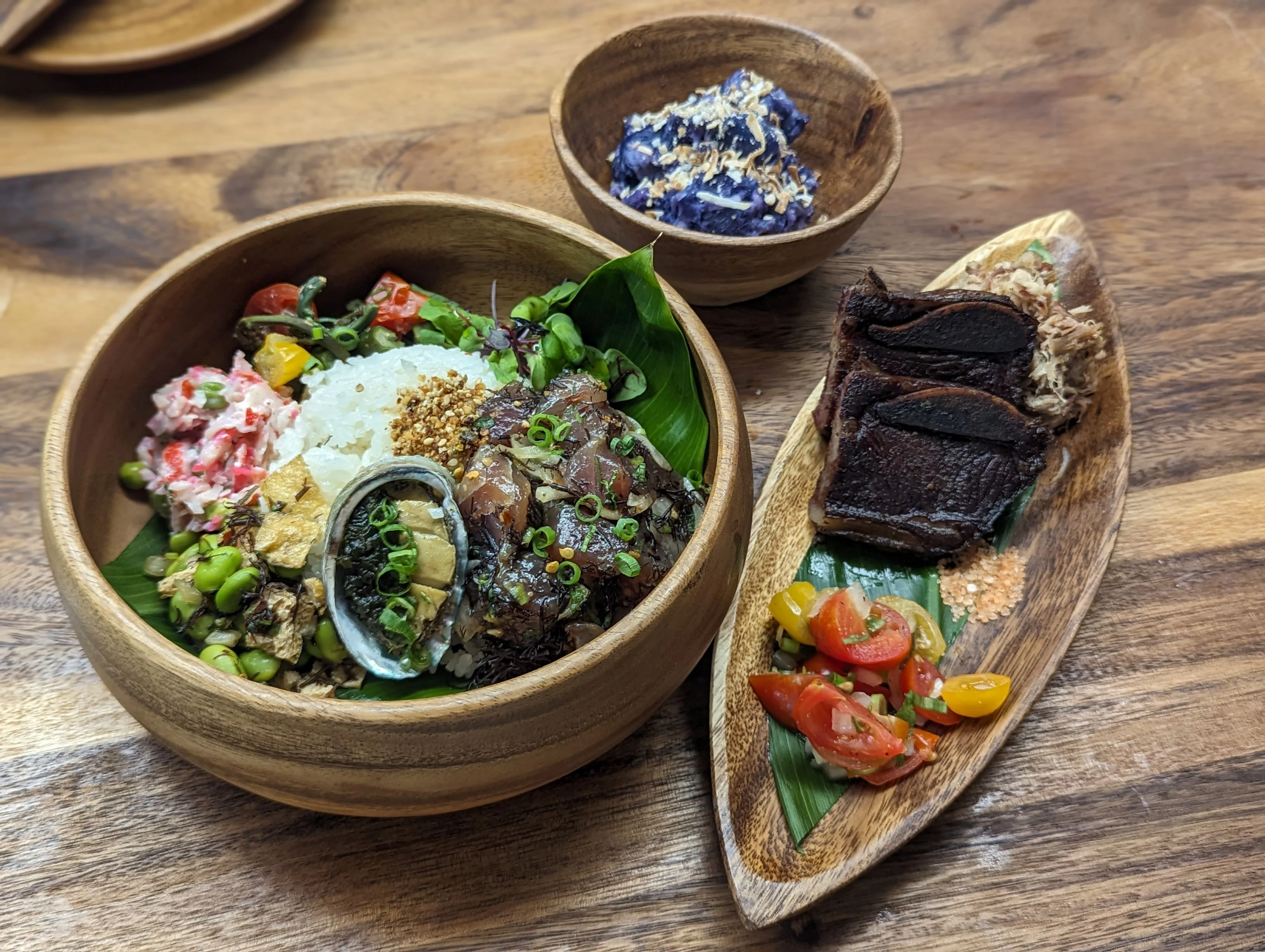 Hawaiian poke bowl with assorted toppings and side dishes