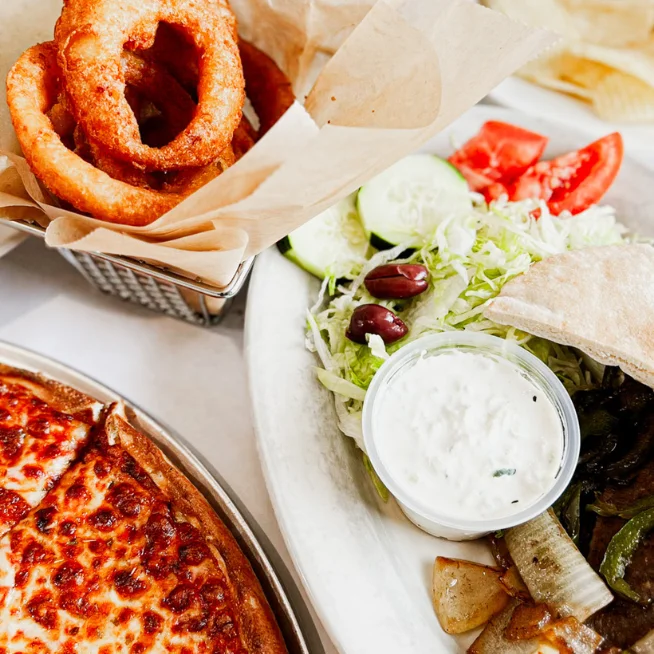 Delicious pepperoni pizza with onion rings and fresh salad