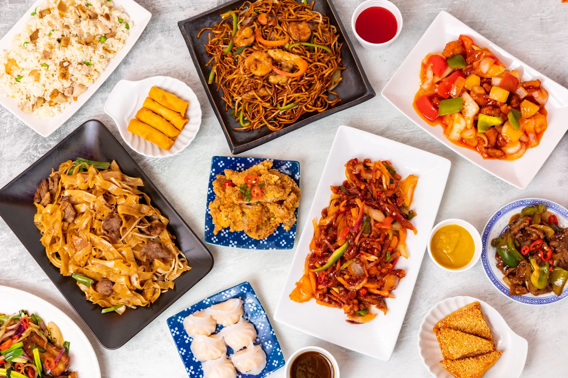 Assorted Chinese dishes including fried rice, noodles, and sweet and sour chicken