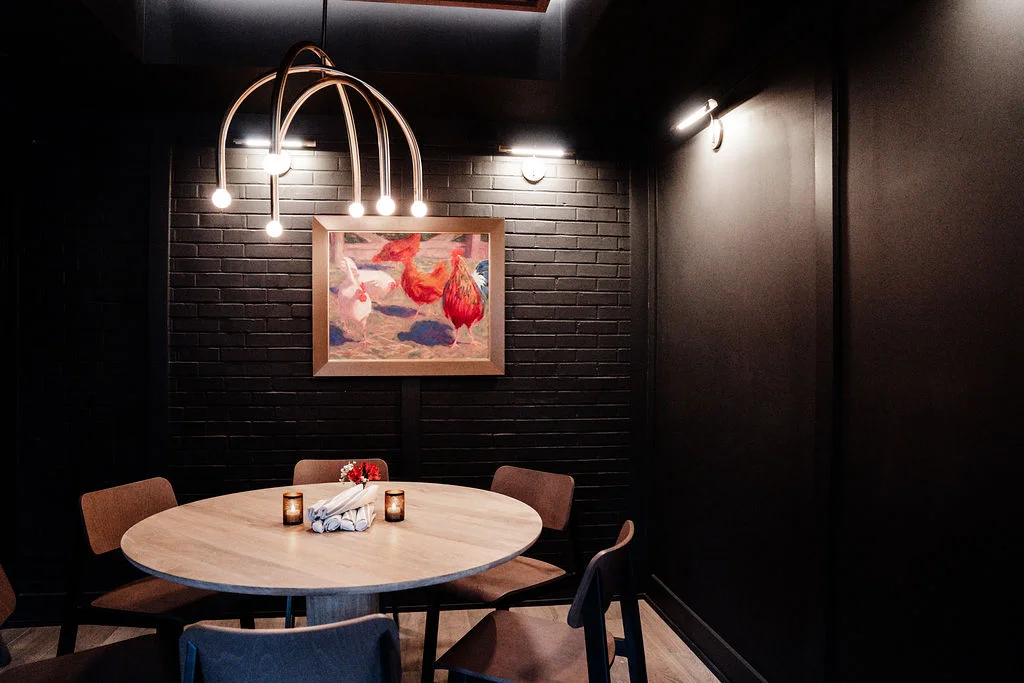 The Embers Room, Firetender's private dining room at Hotel Manteo in Manteo, NC, set for a party with a round table under brass pendant lights