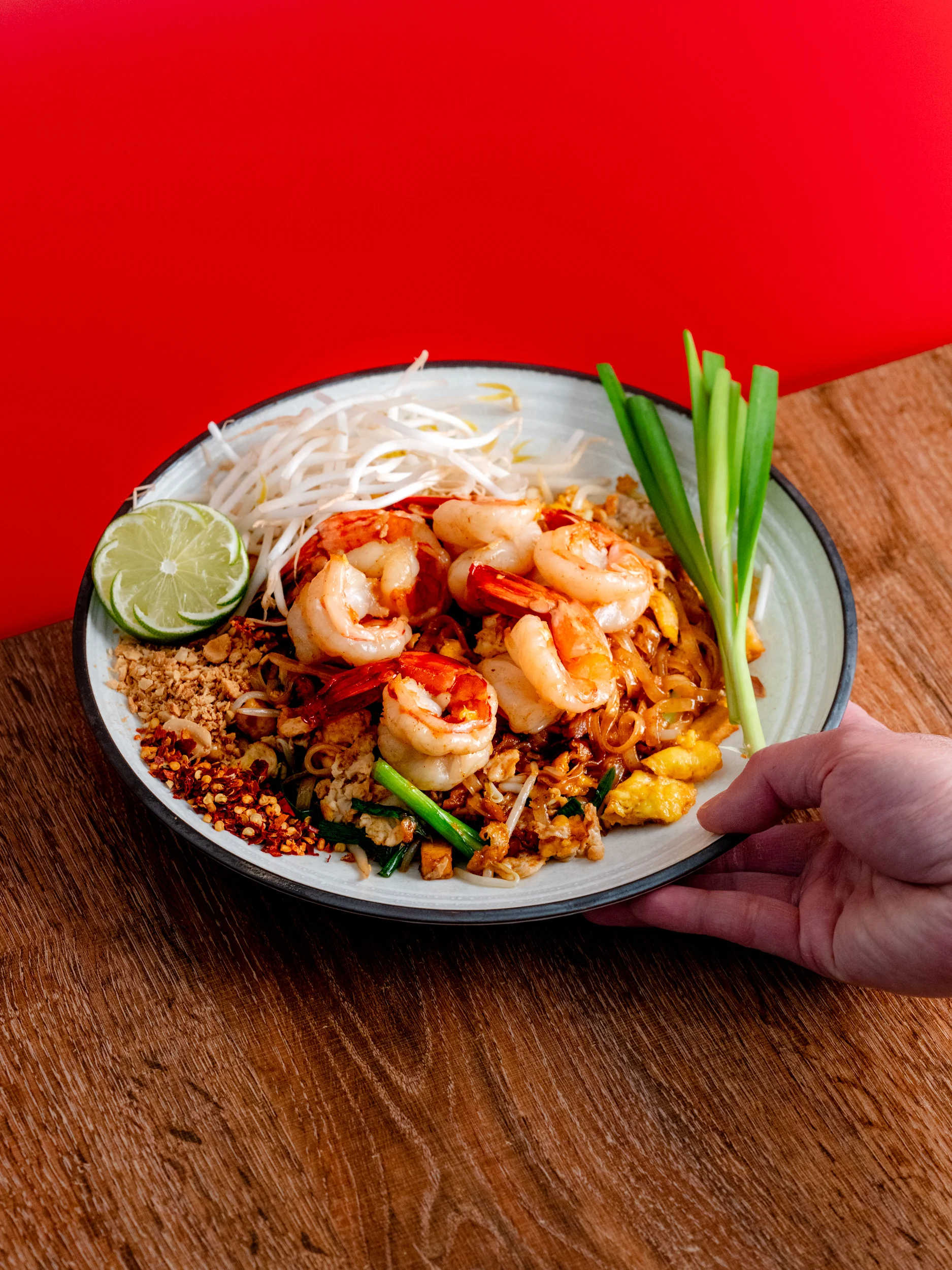 Plate of Thai pad thai with shrimp and fresh lime