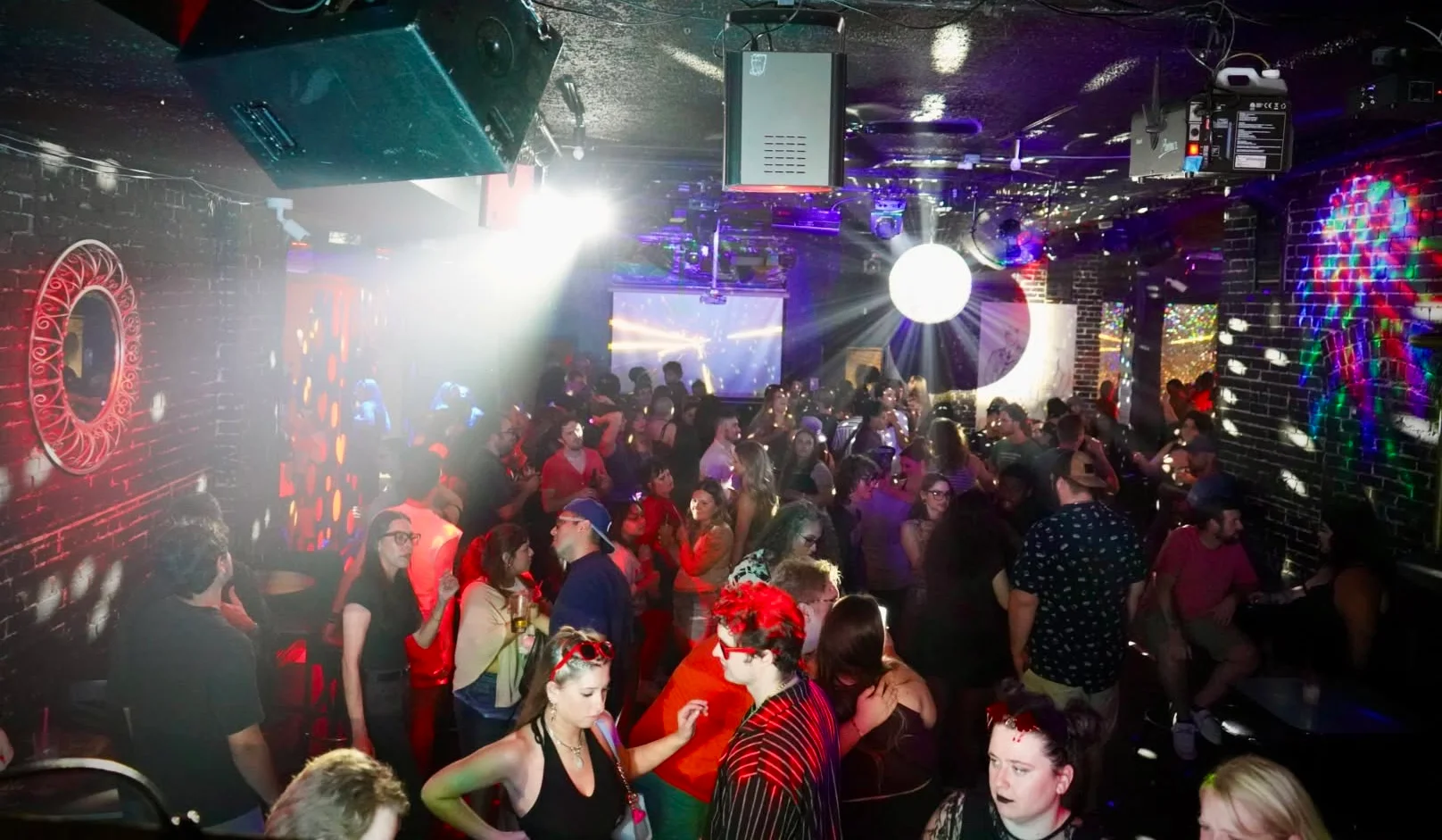 Vibrant nightclub scene with dancing crowd and disco ball