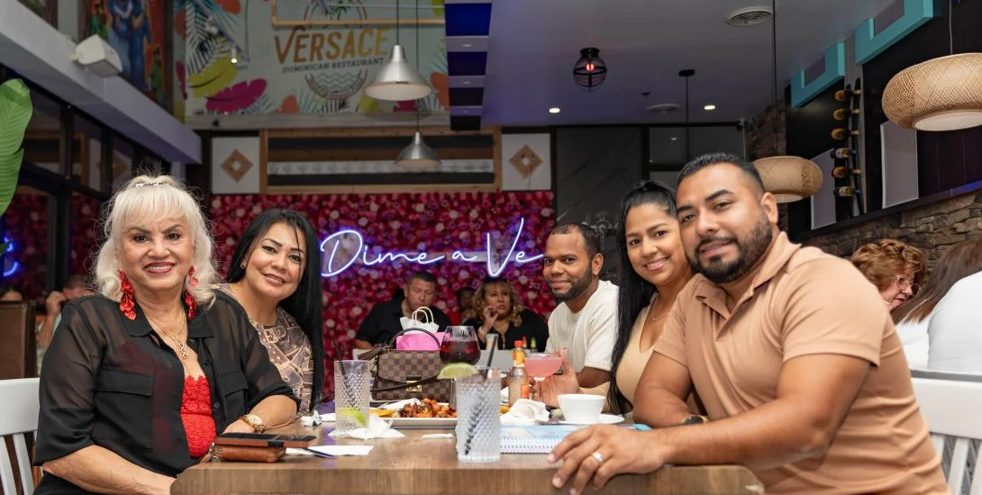 Group of friends enjoying a meal at a vibrant Dominican restaurant.