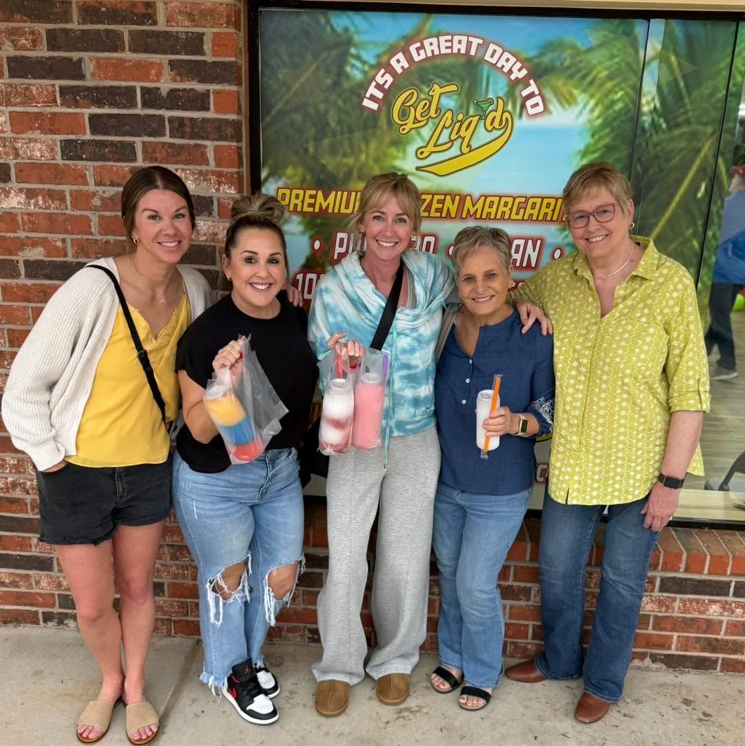 Group of friends enjoying frozen margaritas outside a vibrant restaurant