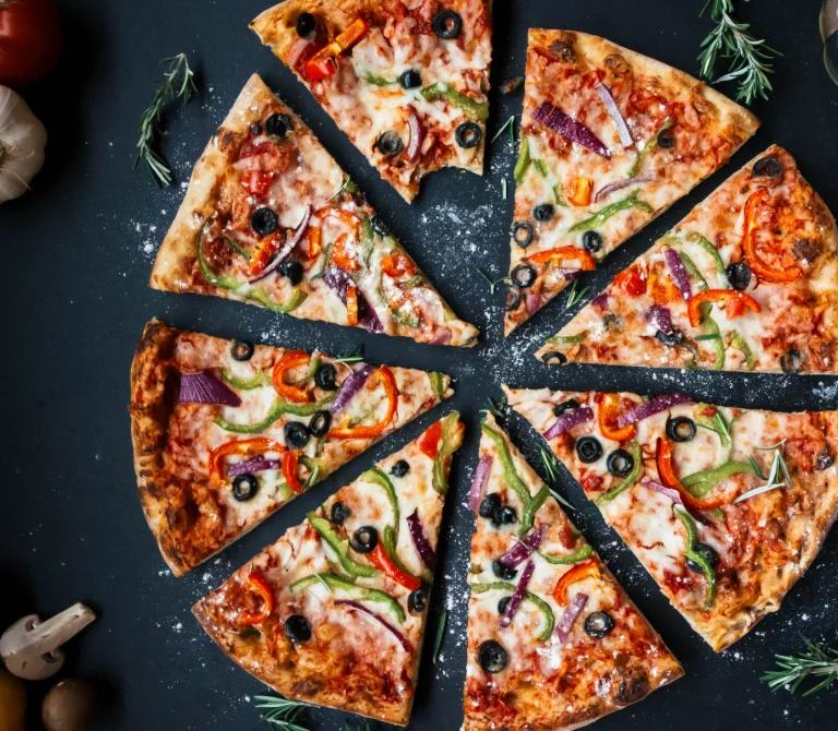 Vegetarian pizza with colorful toppings on a black background