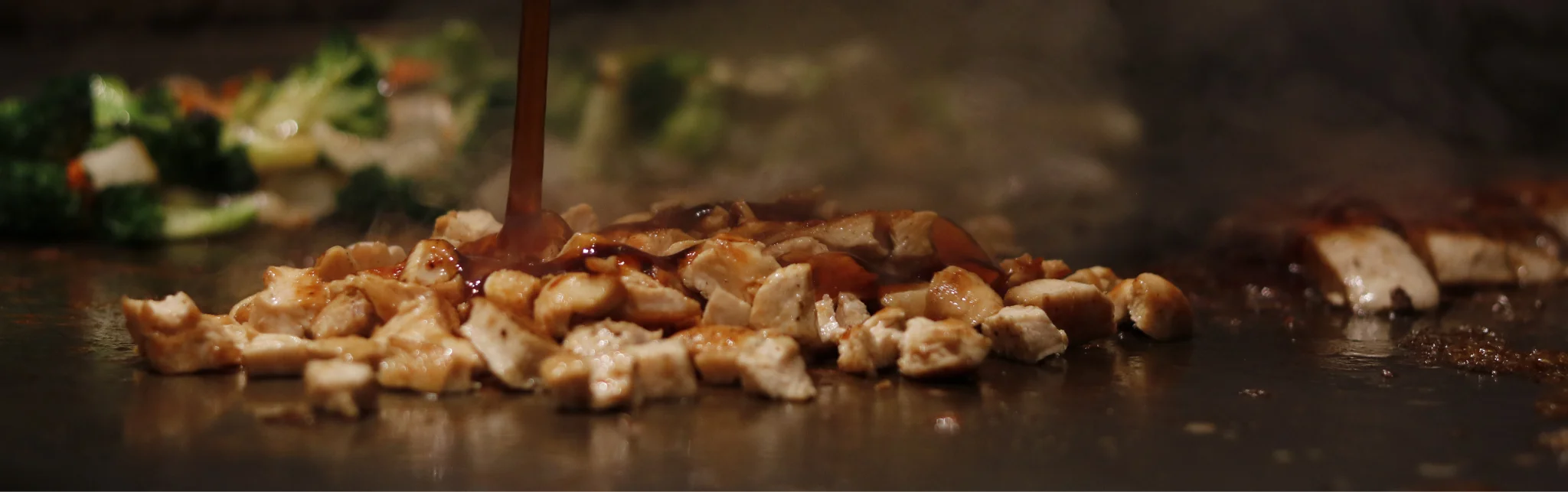 Sizzling hibachi chicken with vegetables on a grill