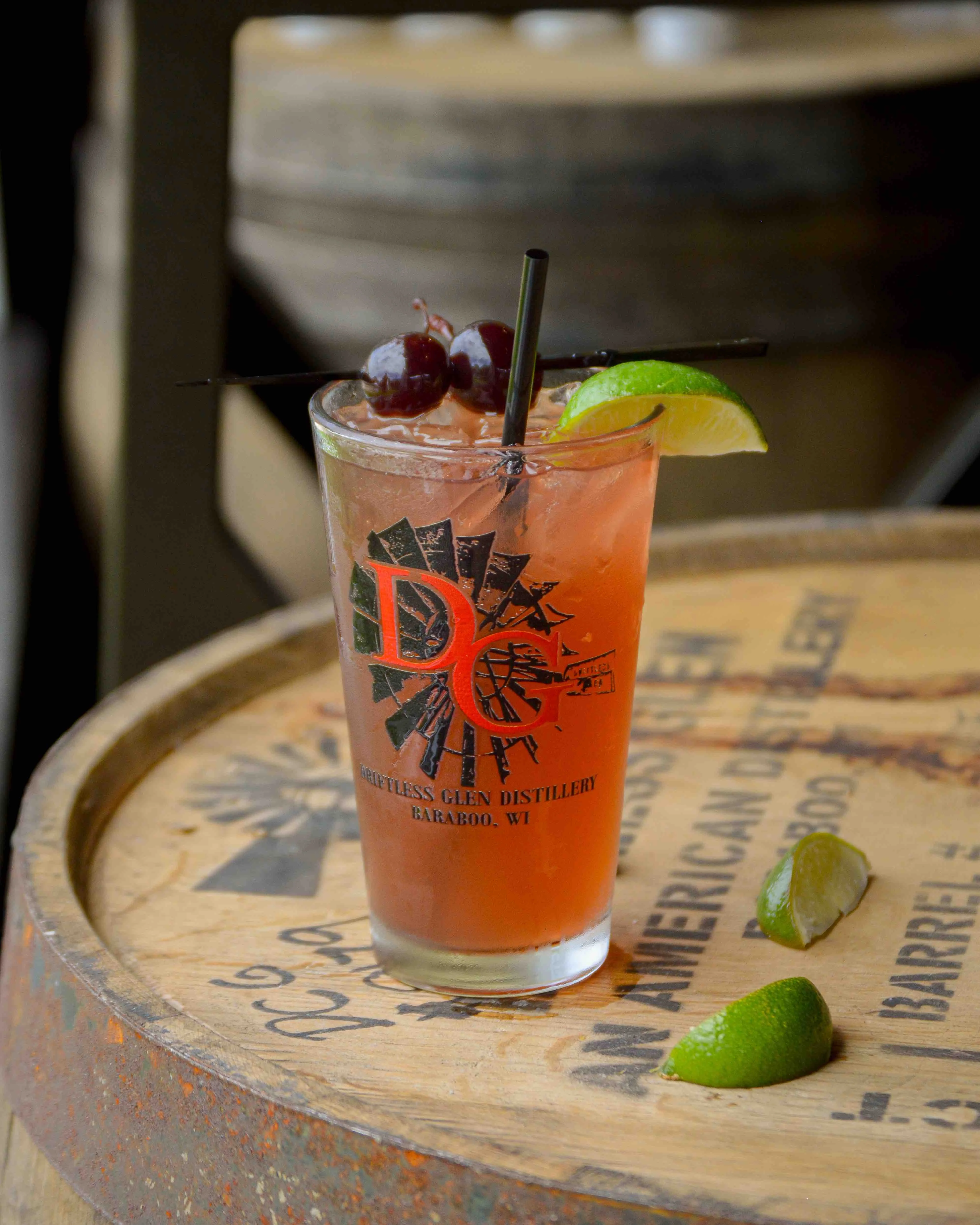 Cherry Cooler sits on a barrel with limes.