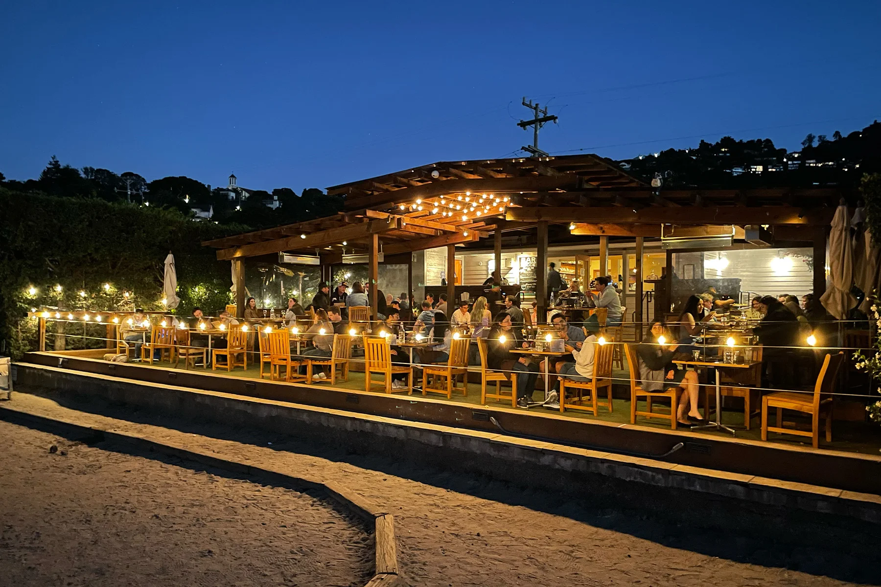 Bar Bocce's green space, people dining outdoors in the evening