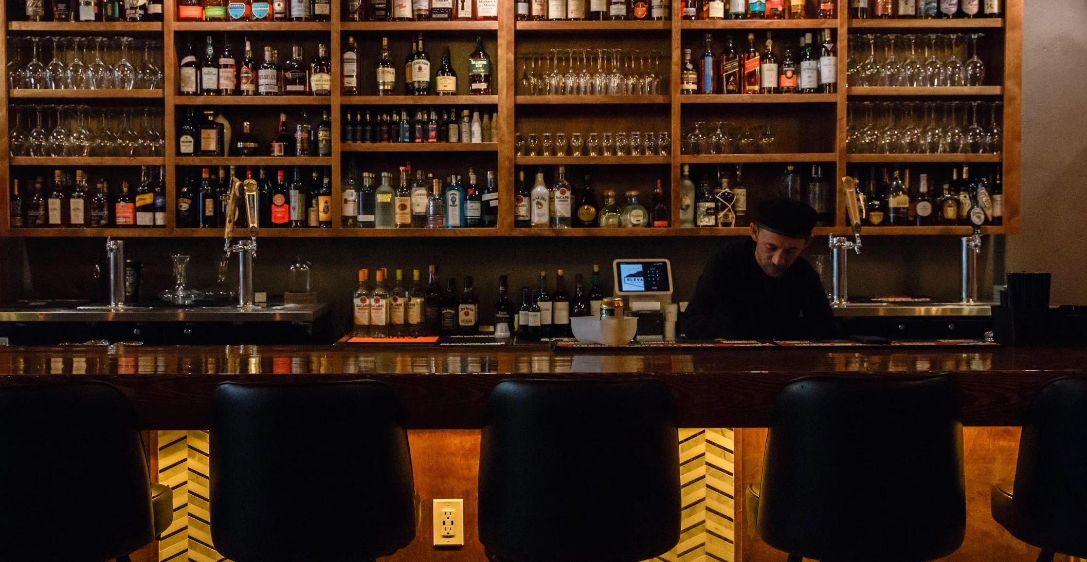 Bartender preparing drinks at a stylish bar counter