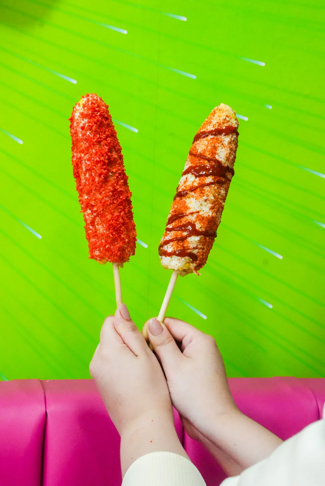 Mexican elote with spicy toppings on colorful background