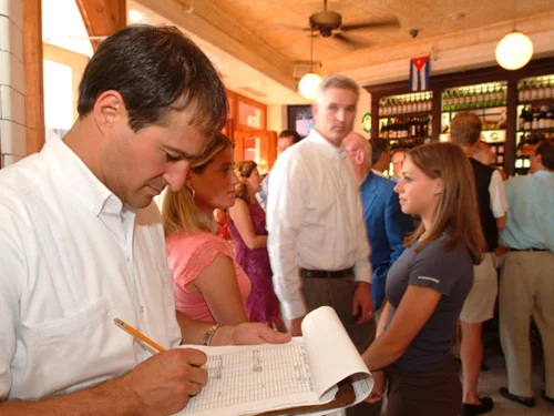 Busy restaurant scene with patrons and a waiter taking notes