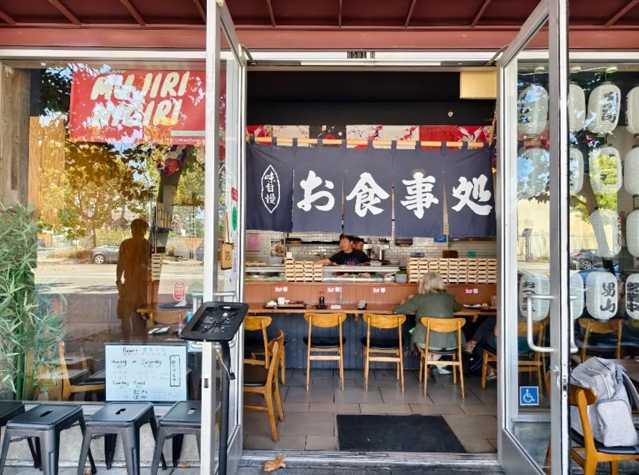 Japanese restaurant entrance with noren curtains and lanterns