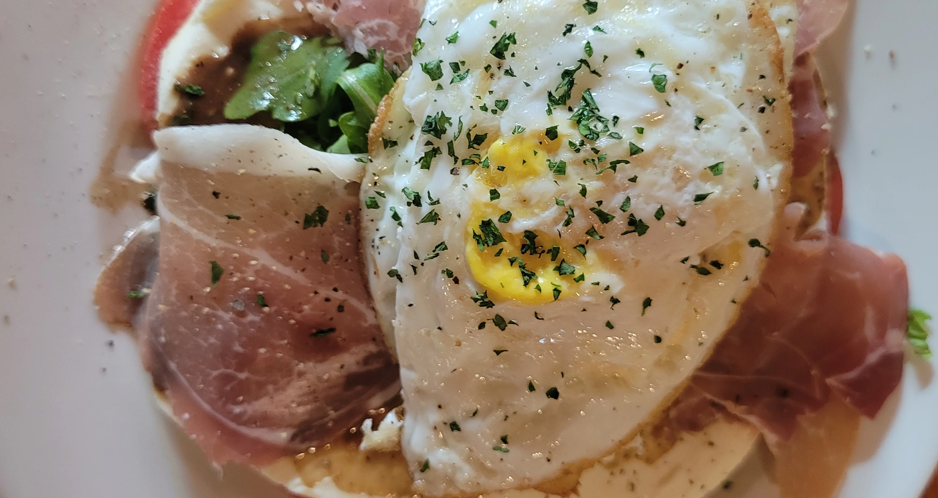 Italian breakfast dish with fried egg and prosciutto