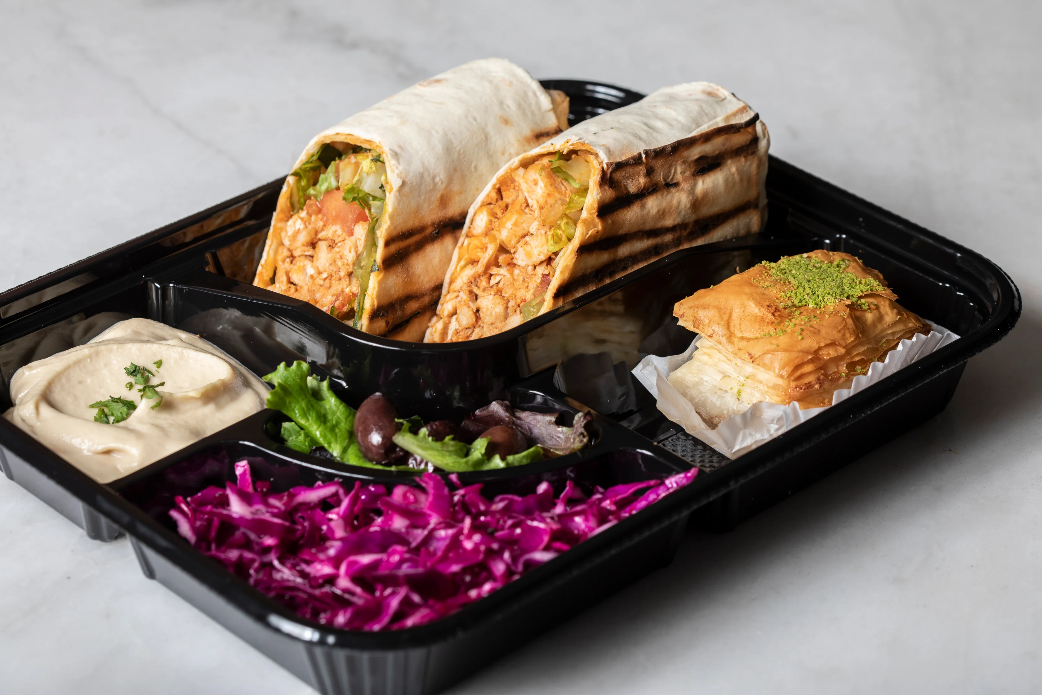 Mediterranean chicken wrap platter with hummus and salad