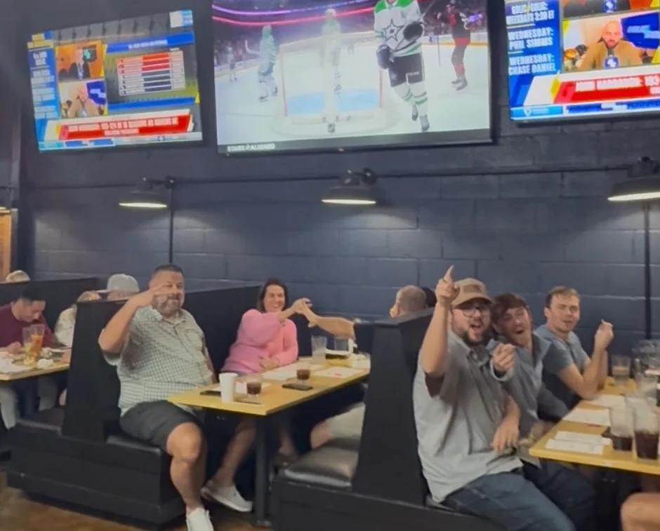 Lively restaurant interior with sports screens and diners enjoying meals