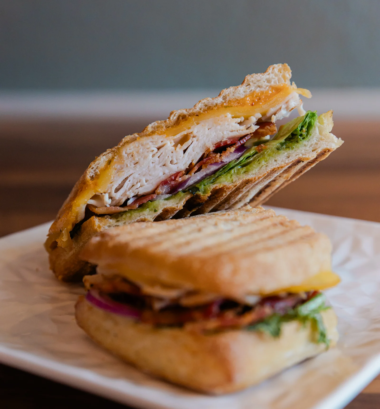 pressed turkey and bacon sandwich on a plate