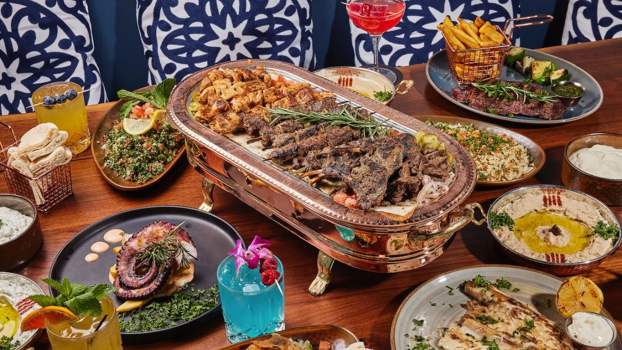 Grilled meats and seafood seasoned with Mediterranean herbs on a rustic table at Sufrat Grill.