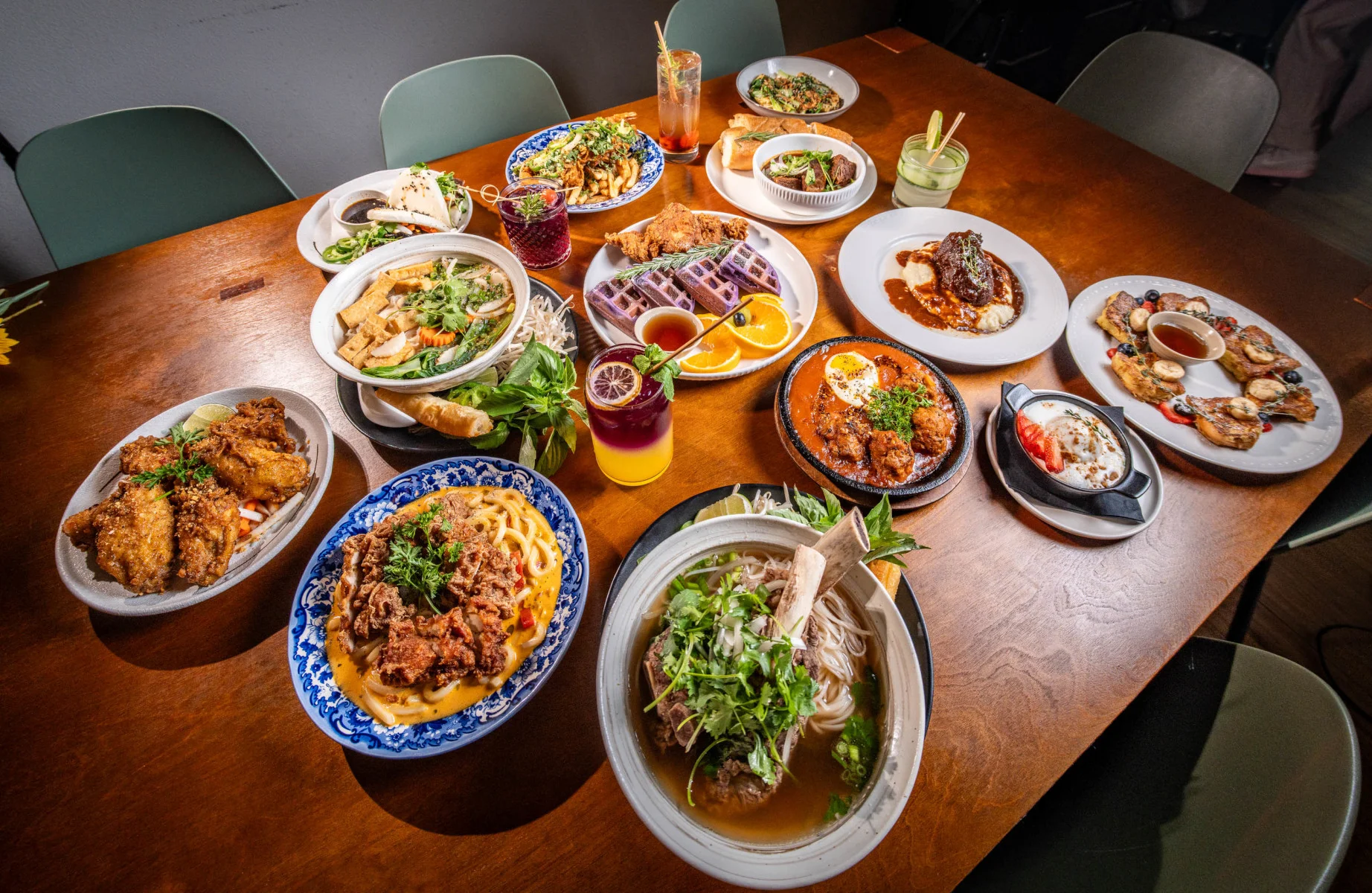 Diverse Asian cuisine spread featuring pho, fried chicken, and noodles