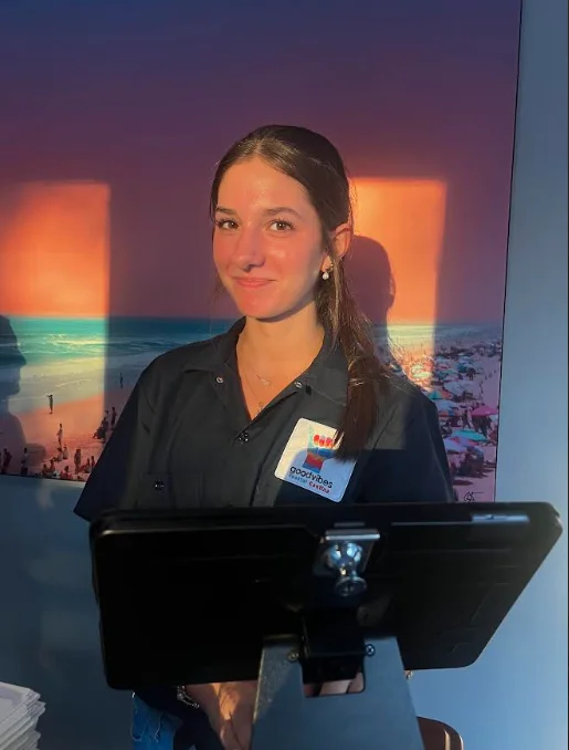 Restaurant staff member at a modern eatery with beach-themed decor