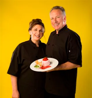 Chefs presenting a dessert plate with vibrant colors