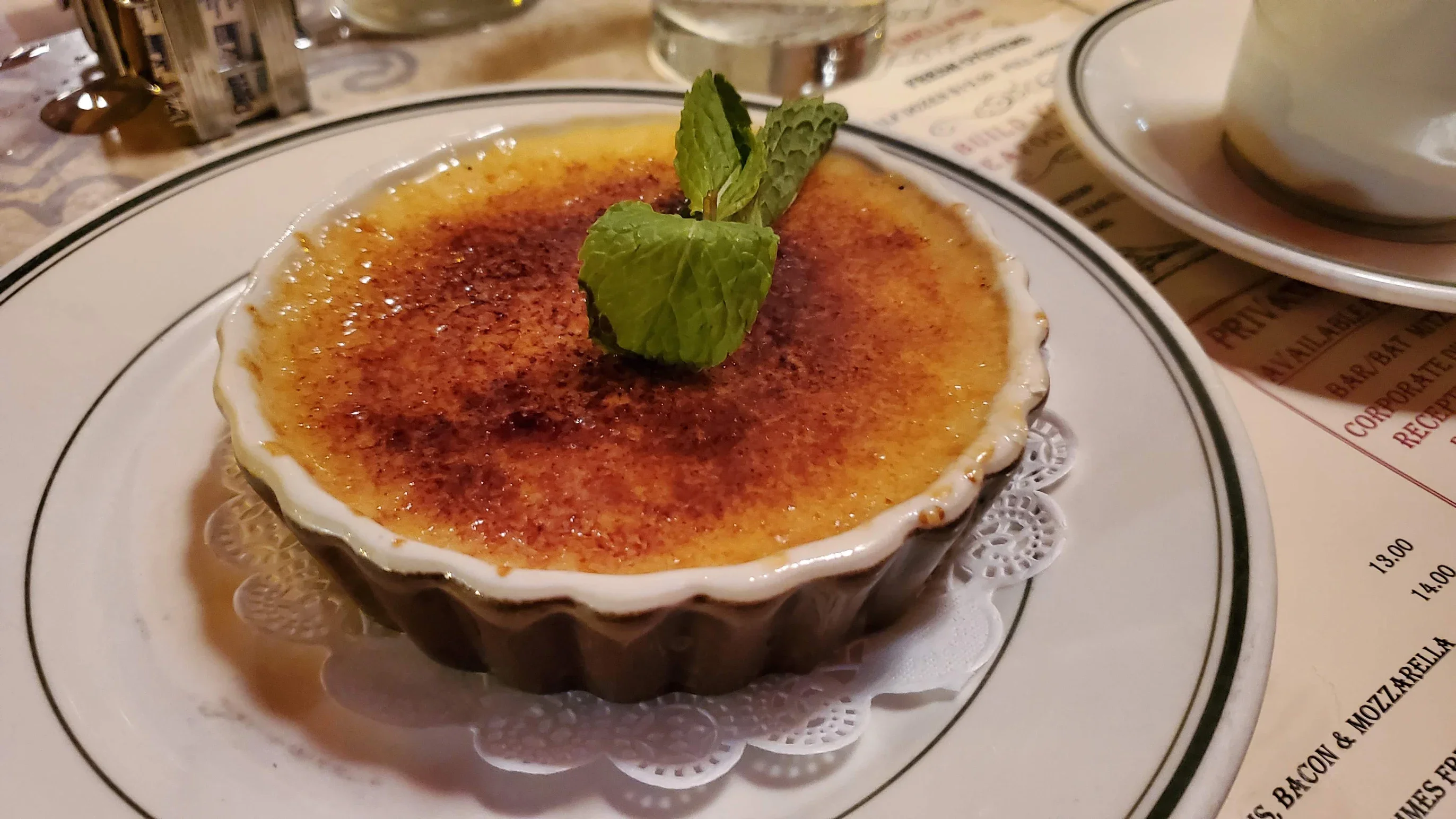 Classic French crème brûlée with caramelized sugar and mint garnish