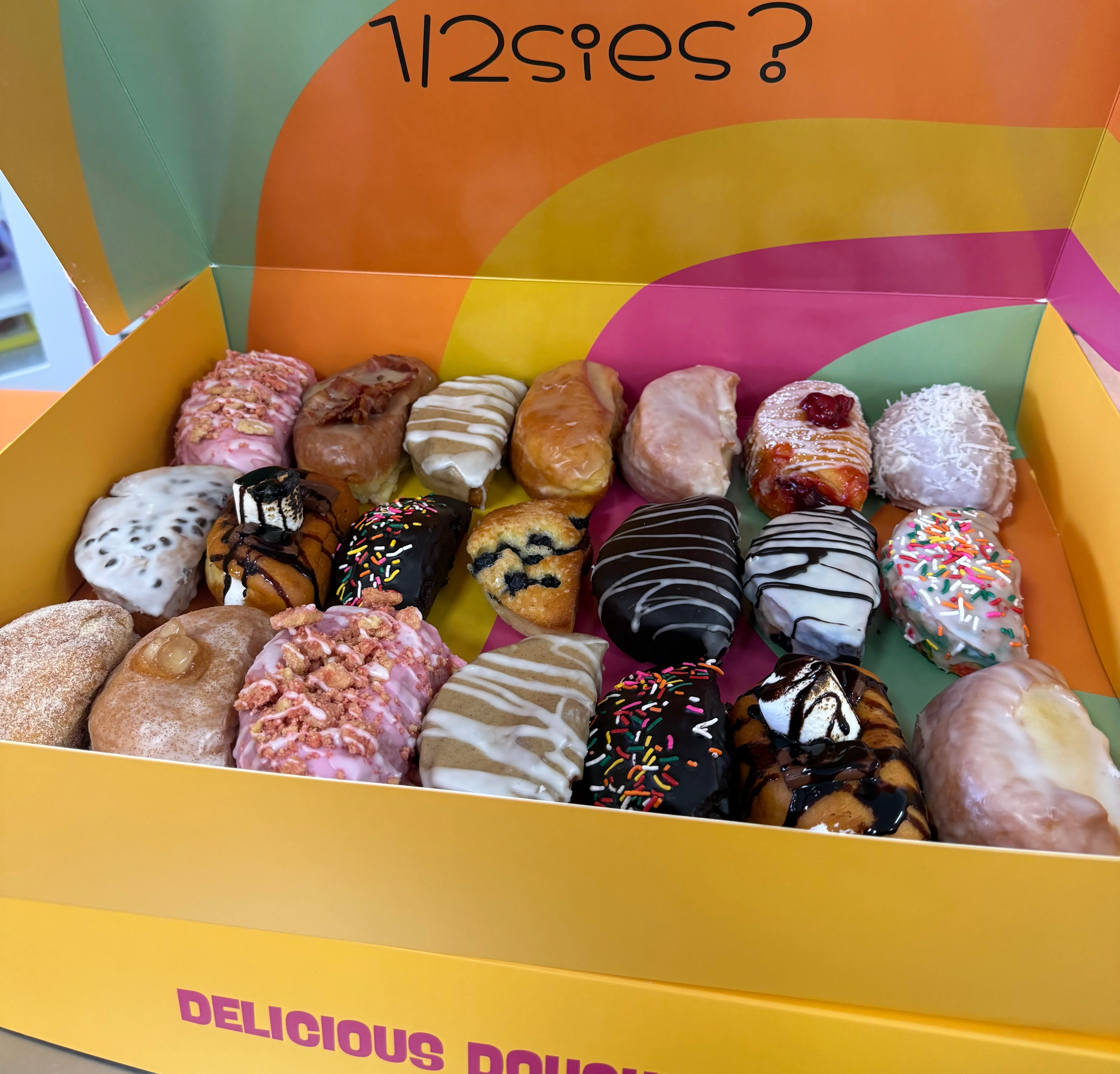Colorful box of mini donuts with toppings and playful design