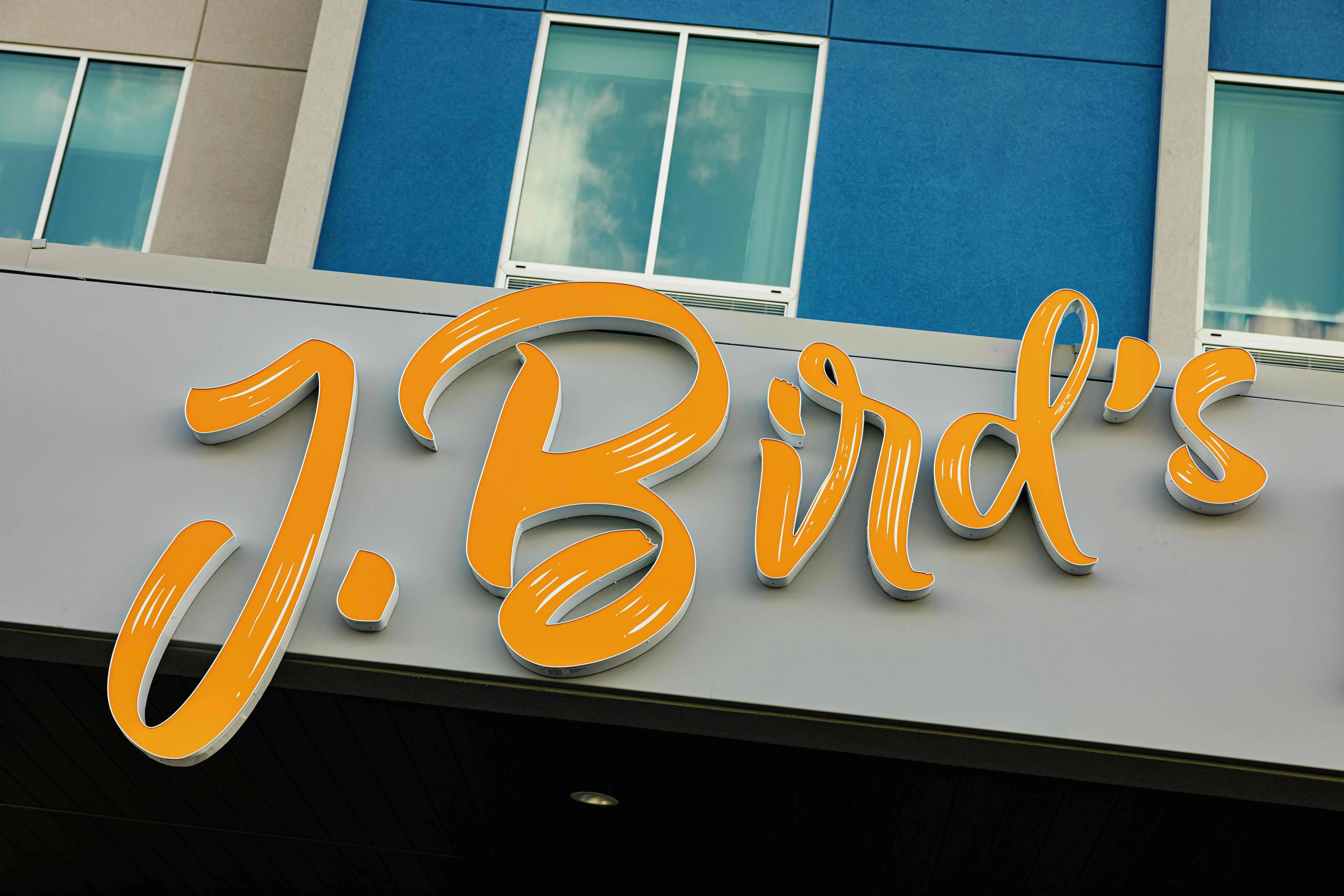 Restaurant sign for J. Bird's with vibrant orange lettering