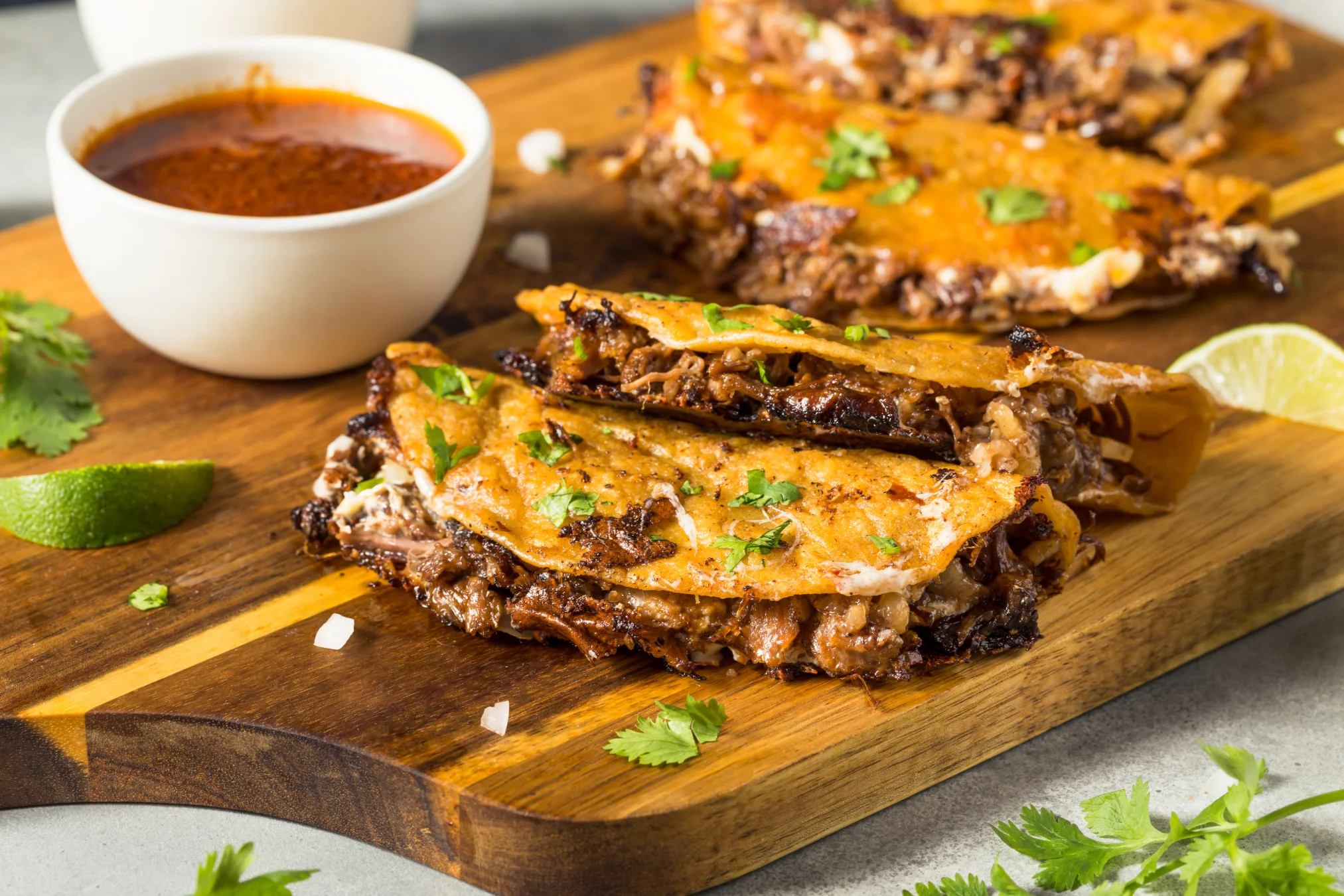 Delicious Mexican quesabirria tacos with consomé