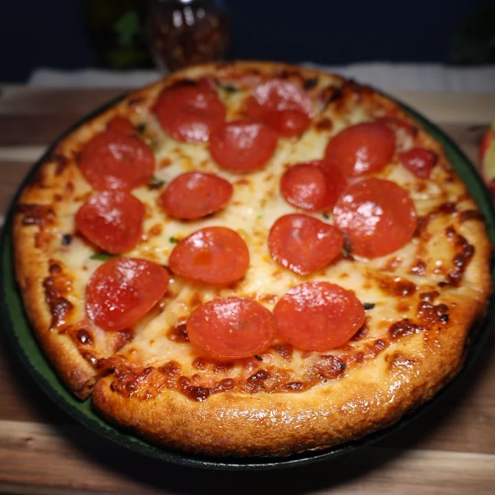 A pepperoni pizza featuring a crispy crust and evenly arranged slices of pepperoni on top.