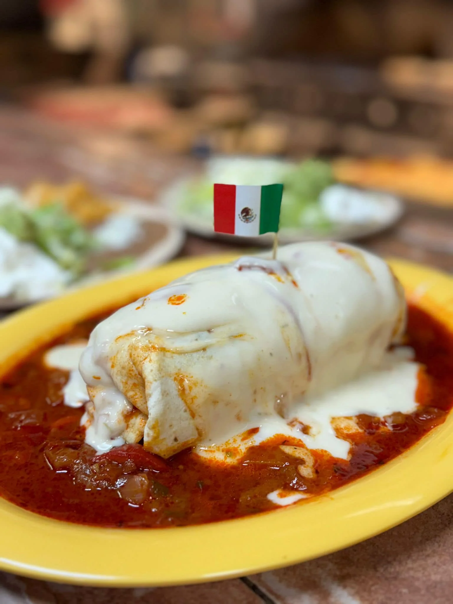 Delicious Mexican burrito smothered in sauce and cheese