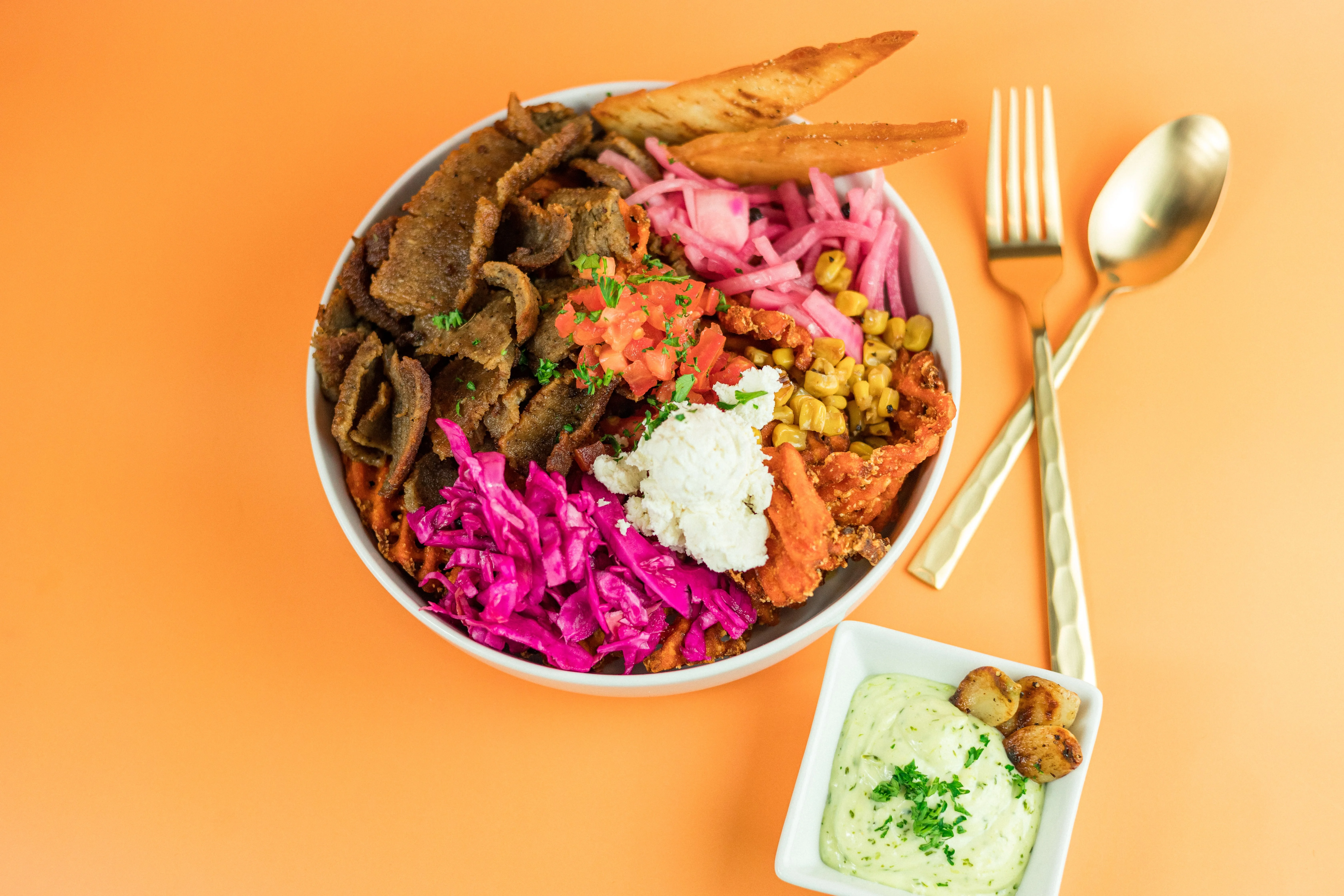 Greek bowl with gyro meat fresh toppings and tzatziki at Santorini's Greek Grill in Sandy Utah