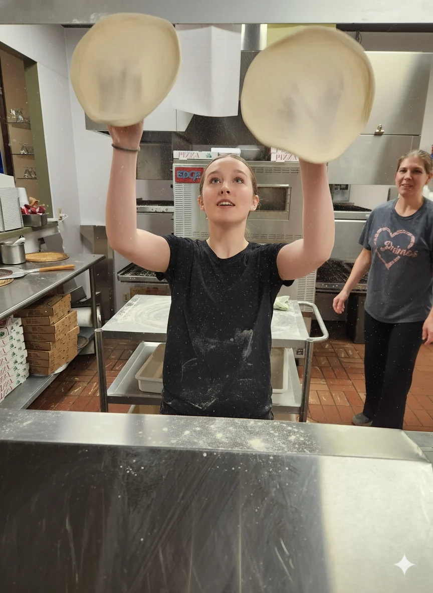 Pizza chef tossing dough in a busy kitchen