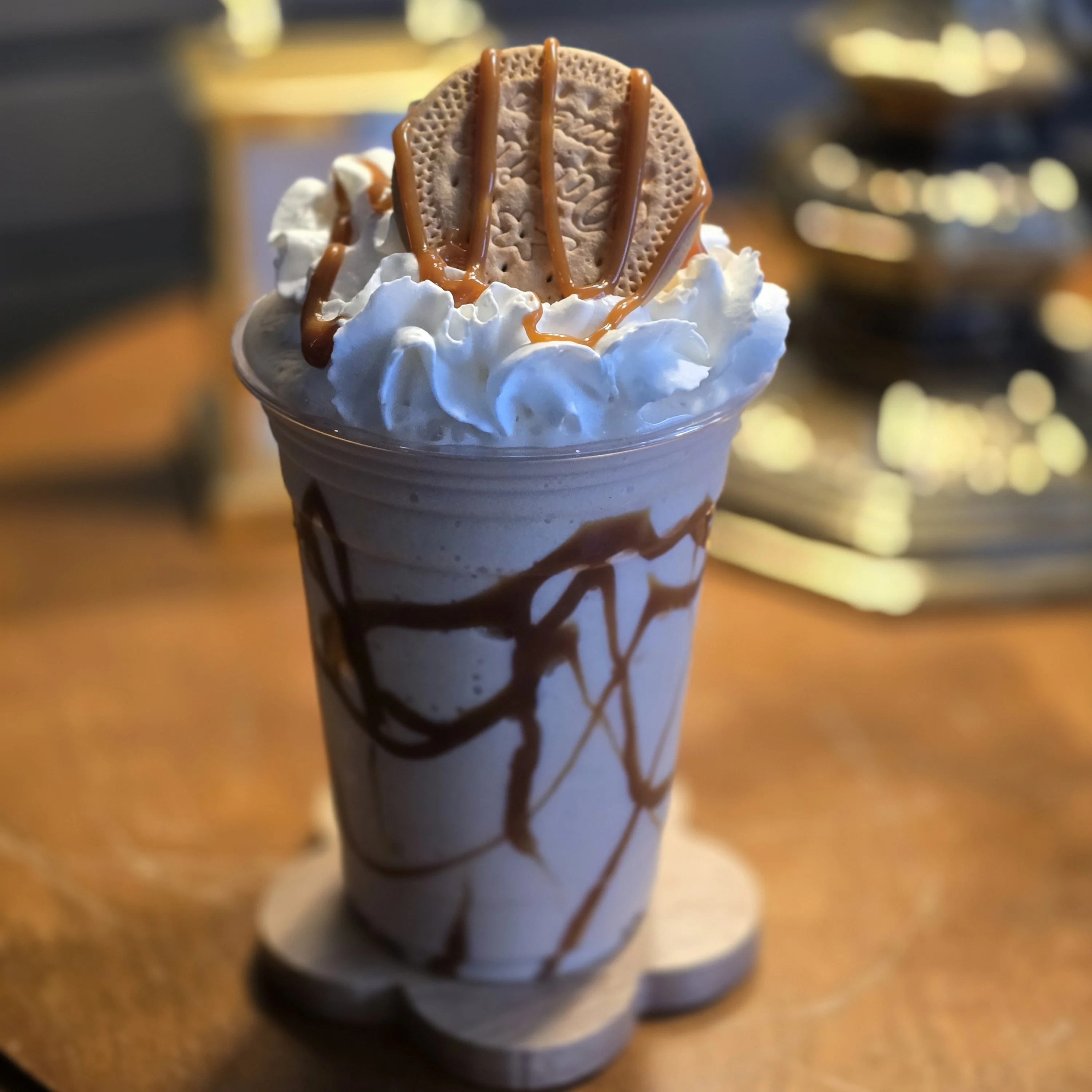 Decadent caramel milkshake topped with whipped cream and cookie