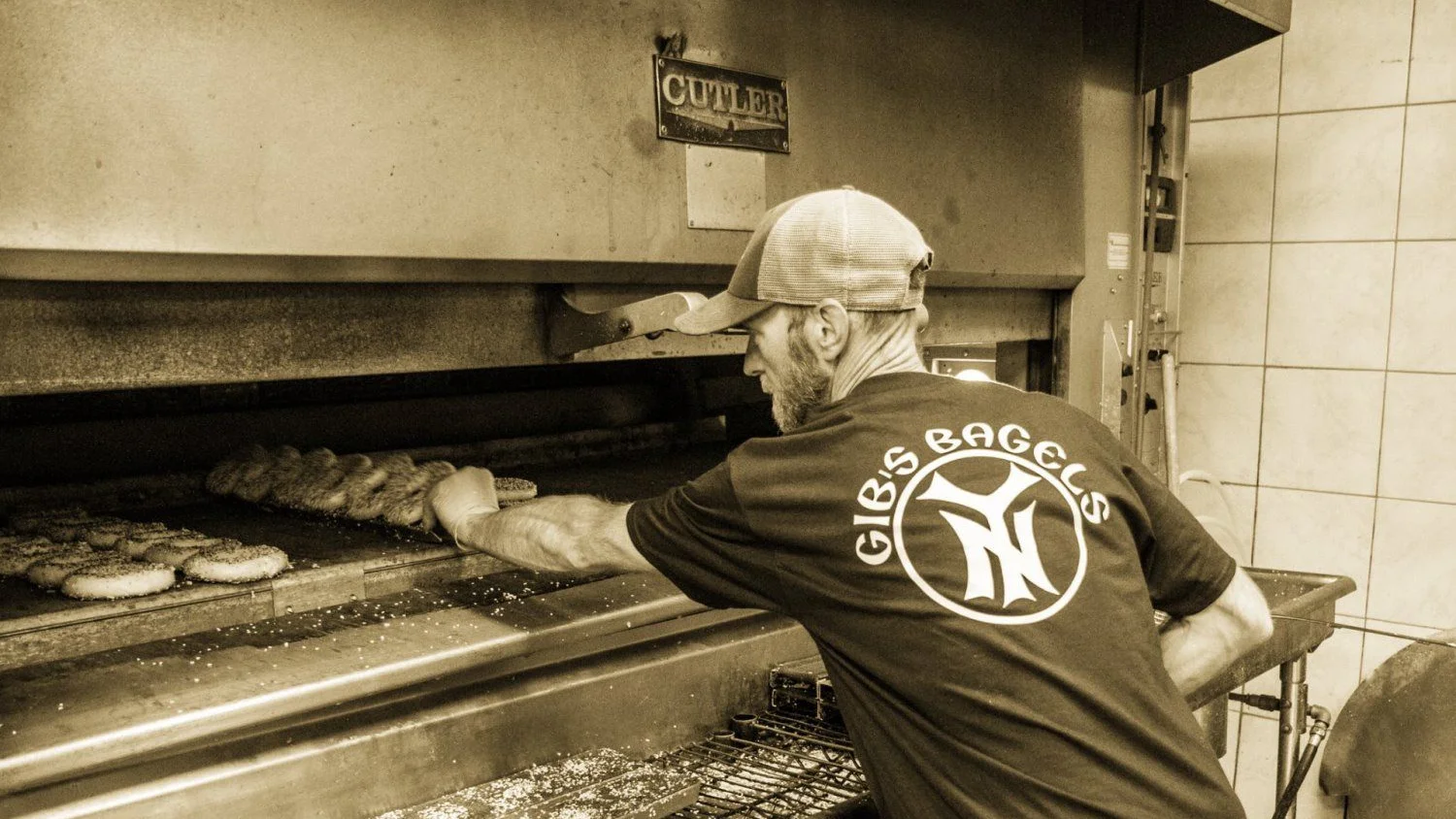A Gibs employee preparing bagels