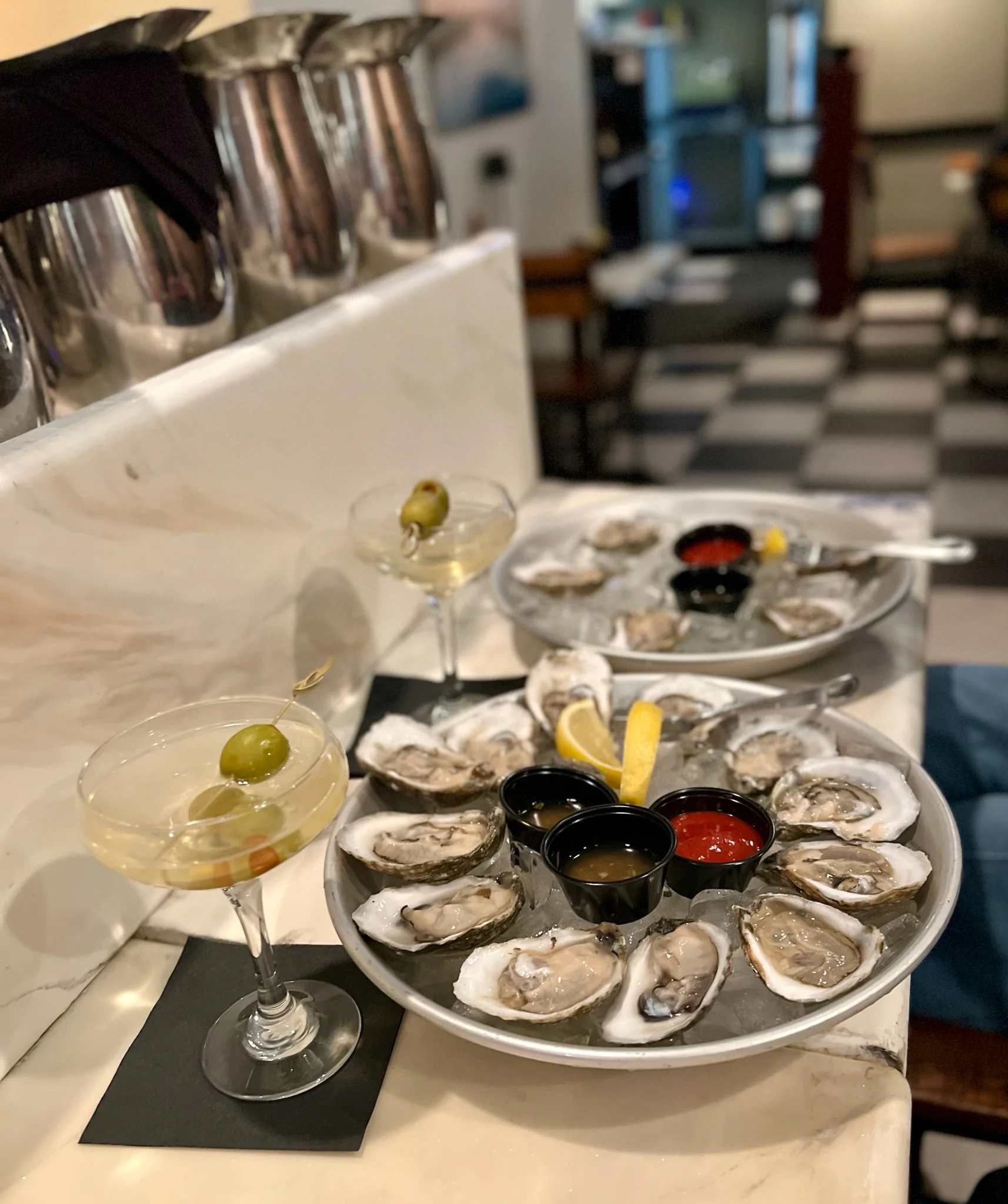 Fresh oysters on a platter with cocktails in a stylish restaurant setting