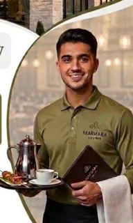 Smiling waiter presenting a tray with coffee and menu in a restaurant setting