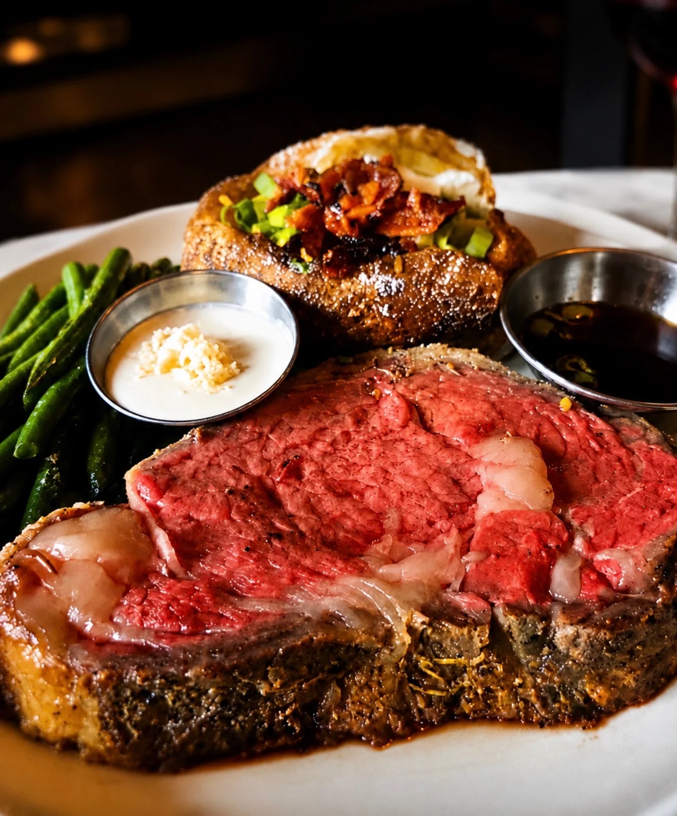 Juicy prime rib with baked potato and green beans on a restaurant plate
