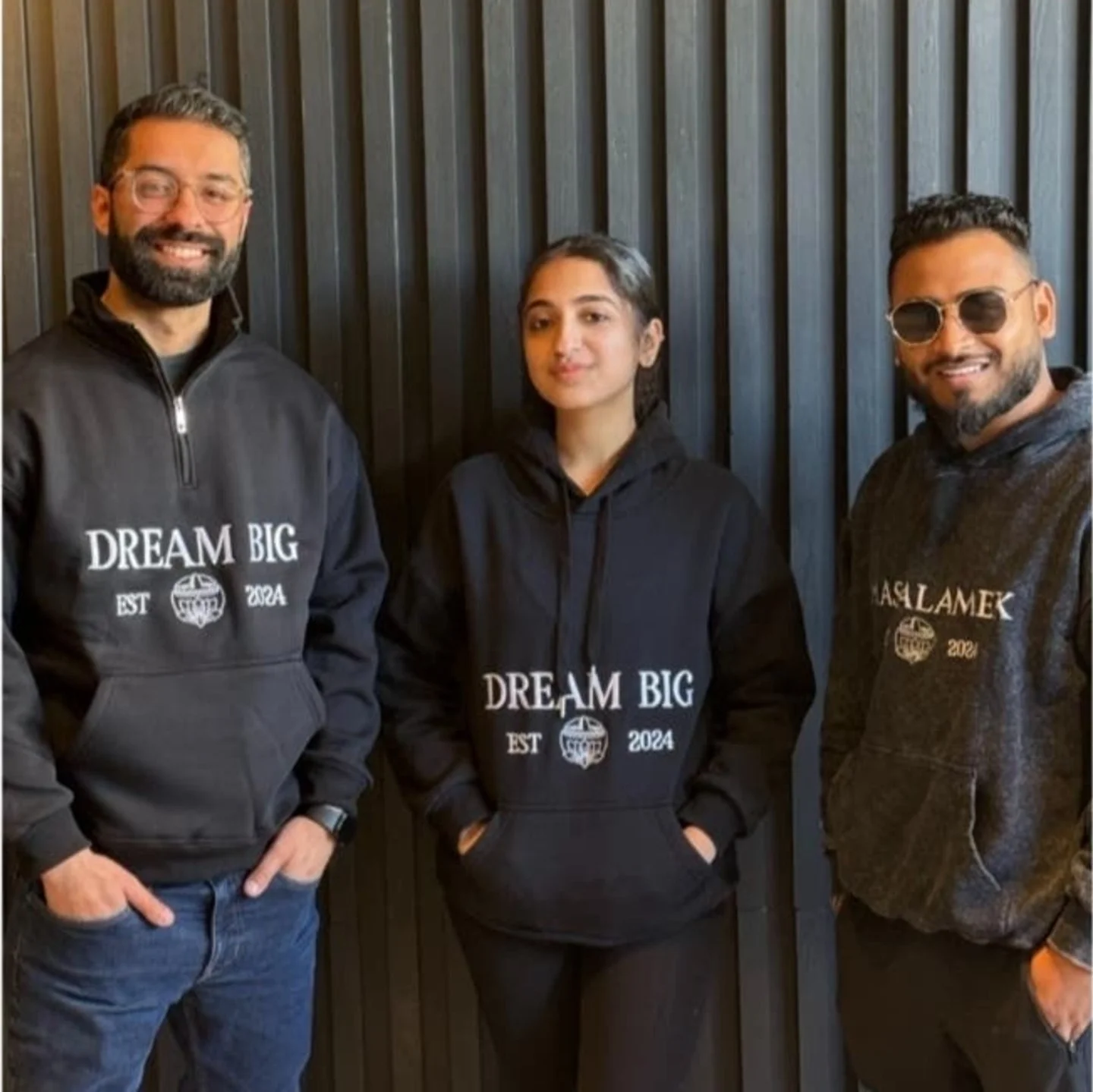 Three individuals in hoodies promoting a positive message