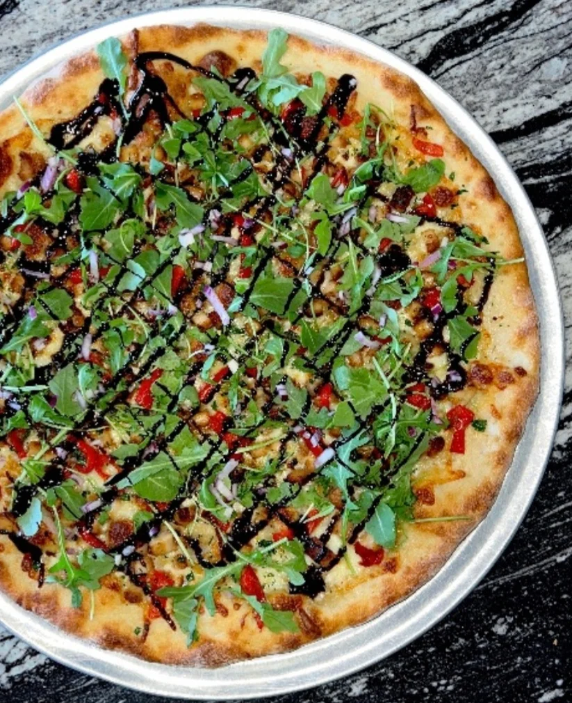 Gourmet flatbread pizza with fresh greens and balsamic drizzle