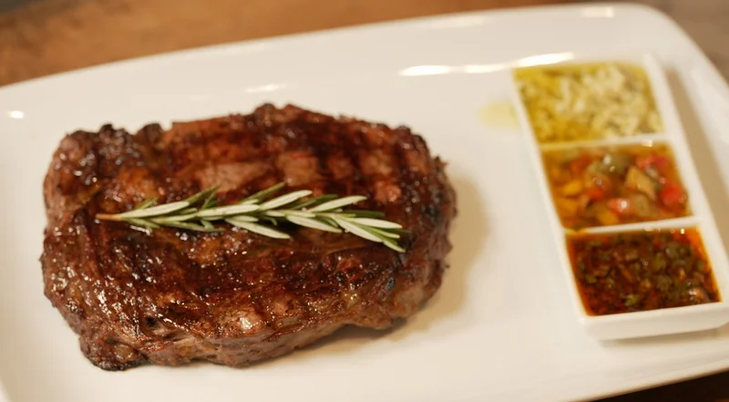 Grilled ribeye steak with rosemary garnish