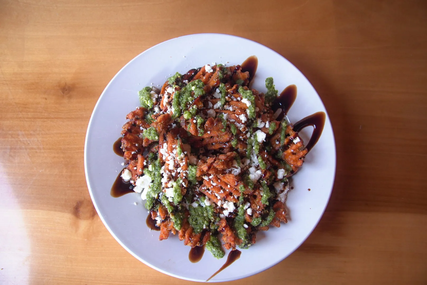 Loaded sweet potato fries with pesto and feta